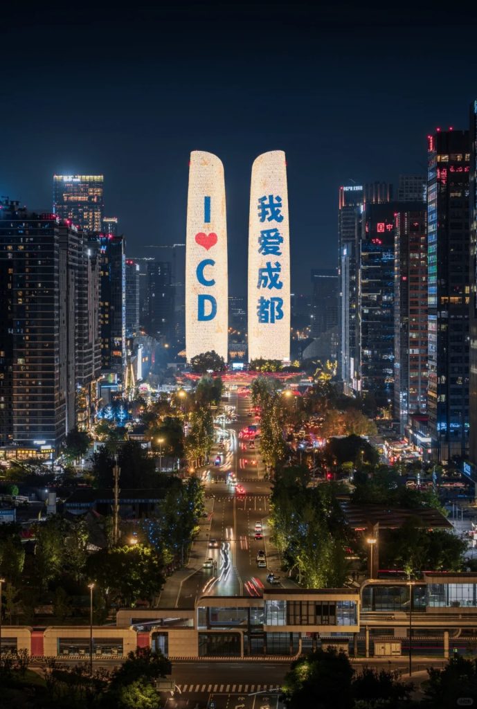 Night view of Chengdu with twin towers lit up displaying 'I ❤️ CD' and '我爱成都'