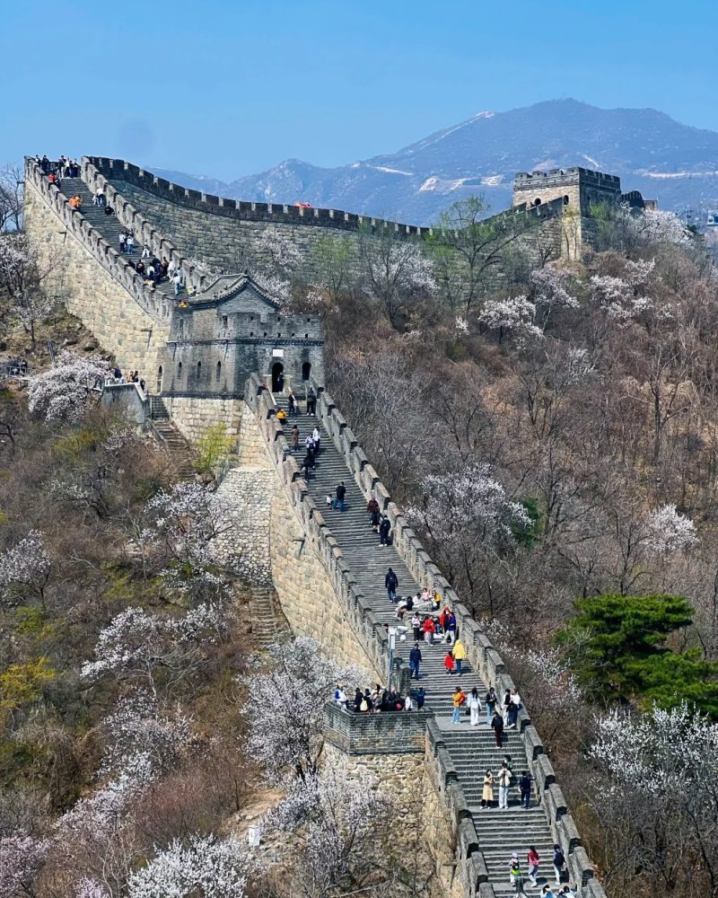 Visitors walking between stone watchtowers on the Mutianyu Great Wall in the mountains north of Beijing
