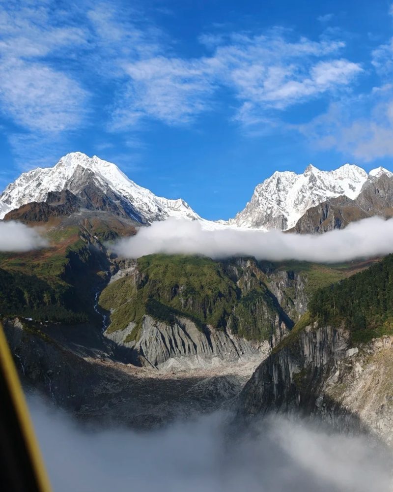 Snow-covered peaks and a glacial valley above low clouds in Hailuogou, Sichuan