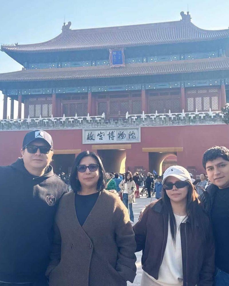 A foreign family enjoying their private tour at the Forbidden City in Beijing on a sunny day.