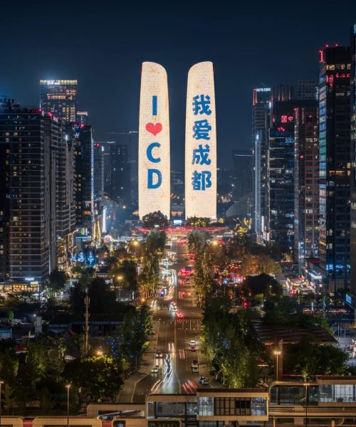 Night view of Chengdu with twin towers lit up displaying 'I ❤️ CD' and '我爱成都'