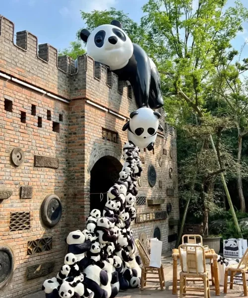 Creative panda sculpture installation on brick wall at Chengdu Panda Base