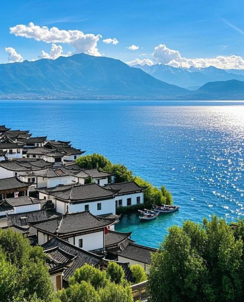 大理洱海迷人的洱海风光，中国传统的白墙民居、游船和蓝天下的苍山为背景。