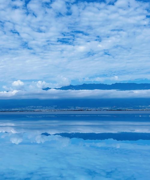 Glass dome structures reflecting sky and clouds beside Erhai Lake – a popular photo spot