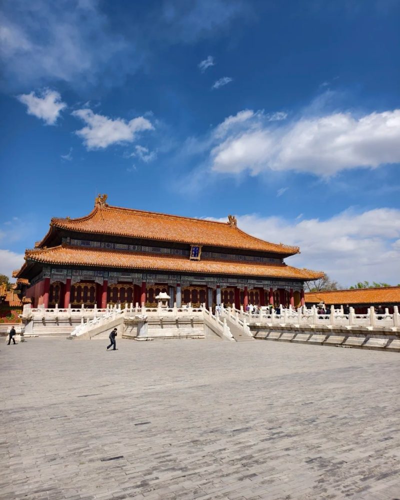 Historic palace hall inside the Forbidden City in Beijing, China, under a bright blue sky