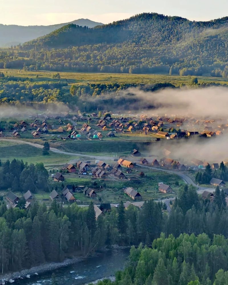 Hemu Village surrounded by green forests and morning mist in Northern Xinjiang