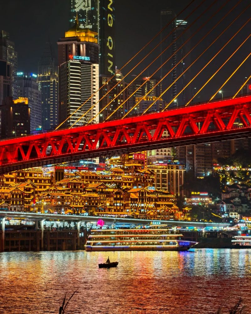 Hongyadong illuminated at night beside the river in Chongqing.