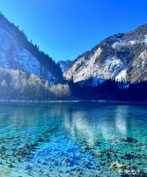 Five Flower Lake in Jiuzhaigou reflecting colorful autumn leaves and mountains
