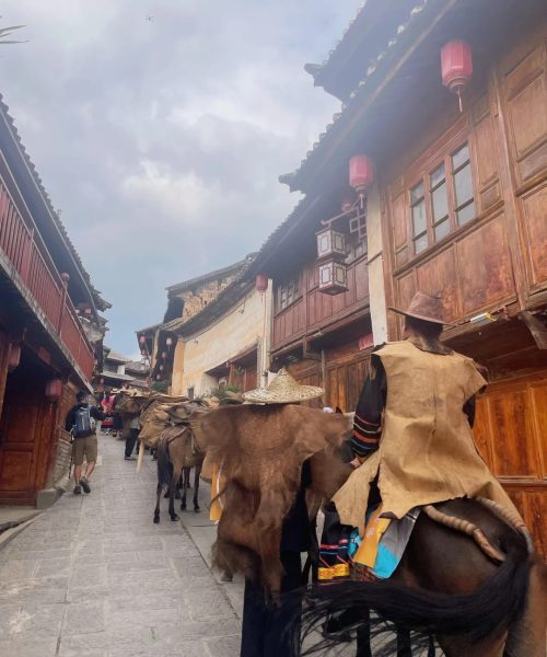 Tourist riding a horse along the ancient Tea Horse Road by Lashi Lake