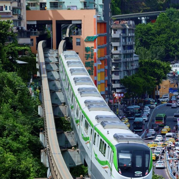 Chongqing’s famous Liziba Monorail running directly through a residential building, surrounded by urban skyline and traffic.