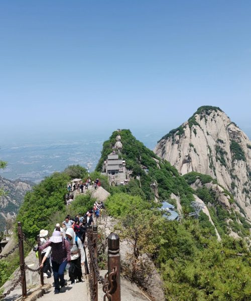 Tourists hiking the scenic trail on Mount Huashan, a famous mountain near Xi’an known for its steep cliffs, cultural significance, and breathtaking views.