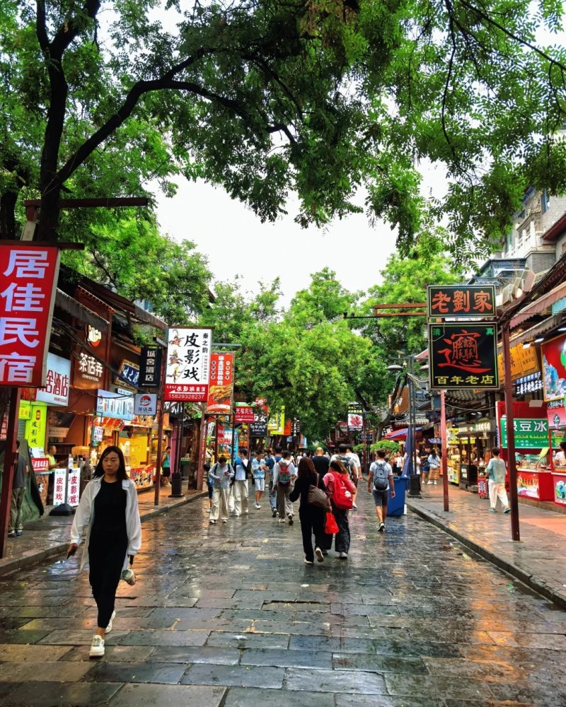 Tourists walking on the stone-paved street of Xi'an Muslim Quarter.