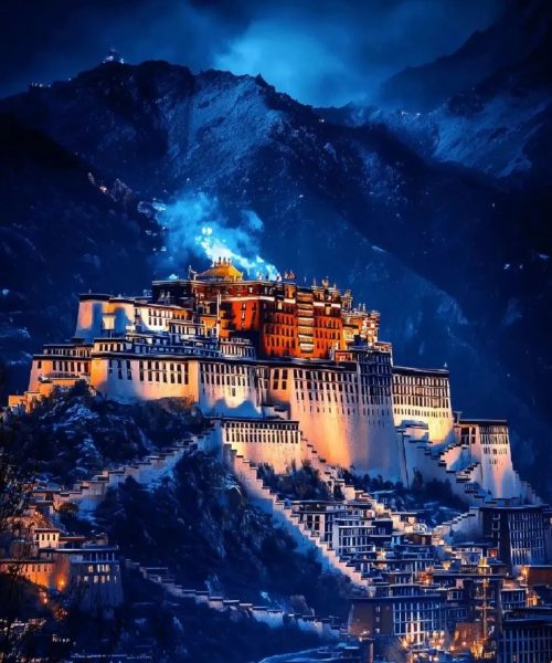 Potala Palace illuminated at night in Lhasa, framed by dark Himalayan mountains