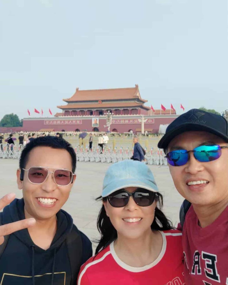 Foreign travelers taking a group photo at Tiananmen Square during a private tour in Beijing