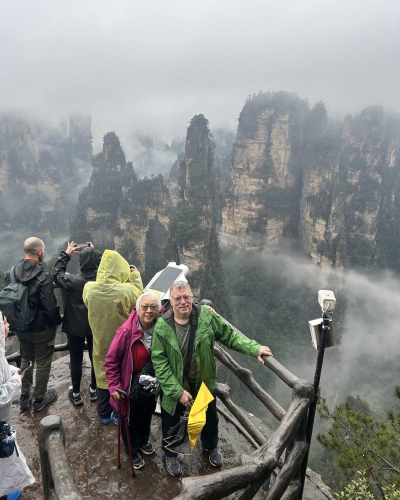 Tocntravel guests at a scenic viewpoint in Zhangjiajie, surrounded by misty sandstone peaks