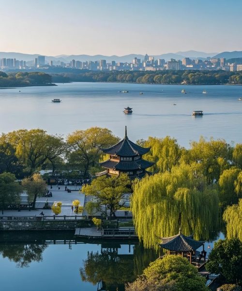 Traditional Chinese pavilion at West Lake with Hangzhou city skyline in the distance.