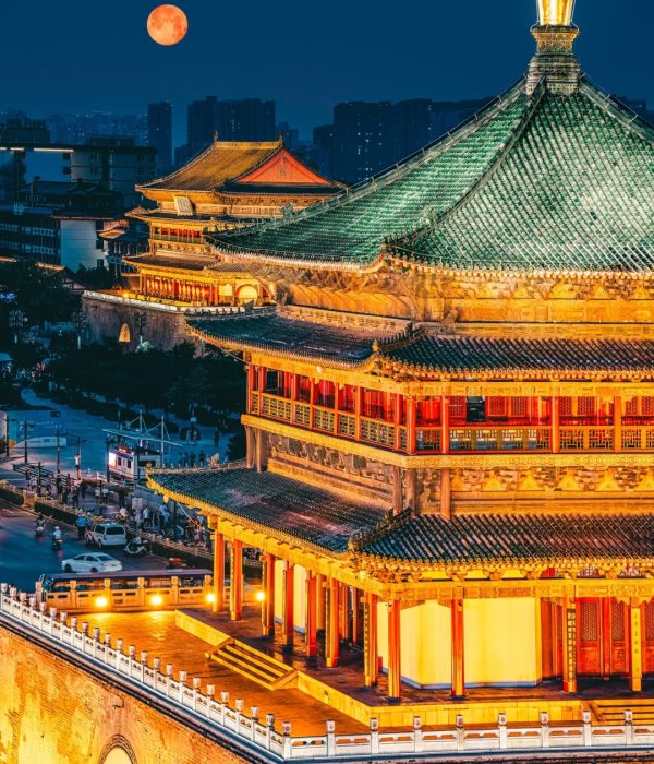 Xi’an Bell Tower at night with a glowing full moon, showcasing the harmony between ancient architecture and modern city life.