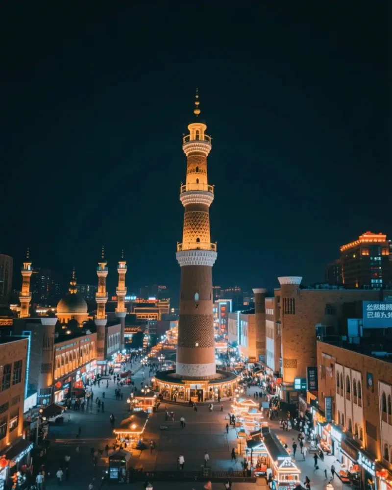 Illuminated tower and market streets at the Xinjiang International Grand Bazaar in Urumqi at night.