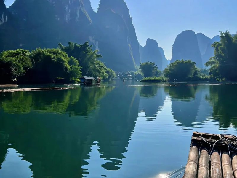 Yulong River, Yangshuo Guilin Yulong River scenery in Yangshuo, Guilin with karst mountains and a bamboo raft on calm water